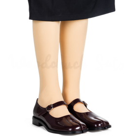 Brown shoes worn with a black skirt on a white background